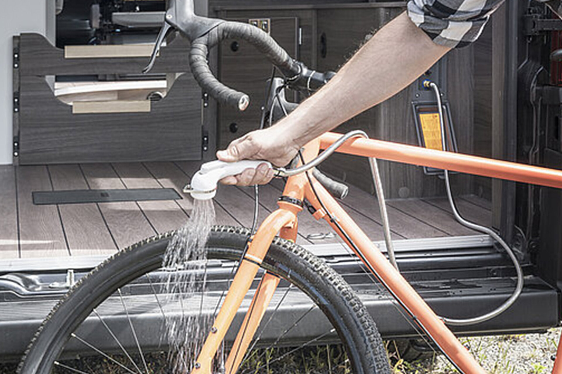 Ein Mann reinigt hinter dem VANTourer sein Fahrrad.