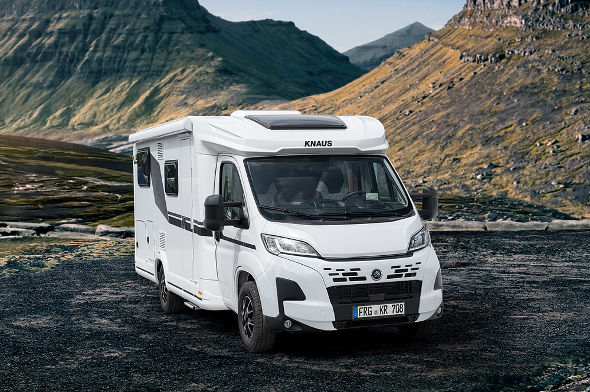 A KNAUS L!VE TI PLATINUM SELECTION stands in a picturesque mountain landscape.