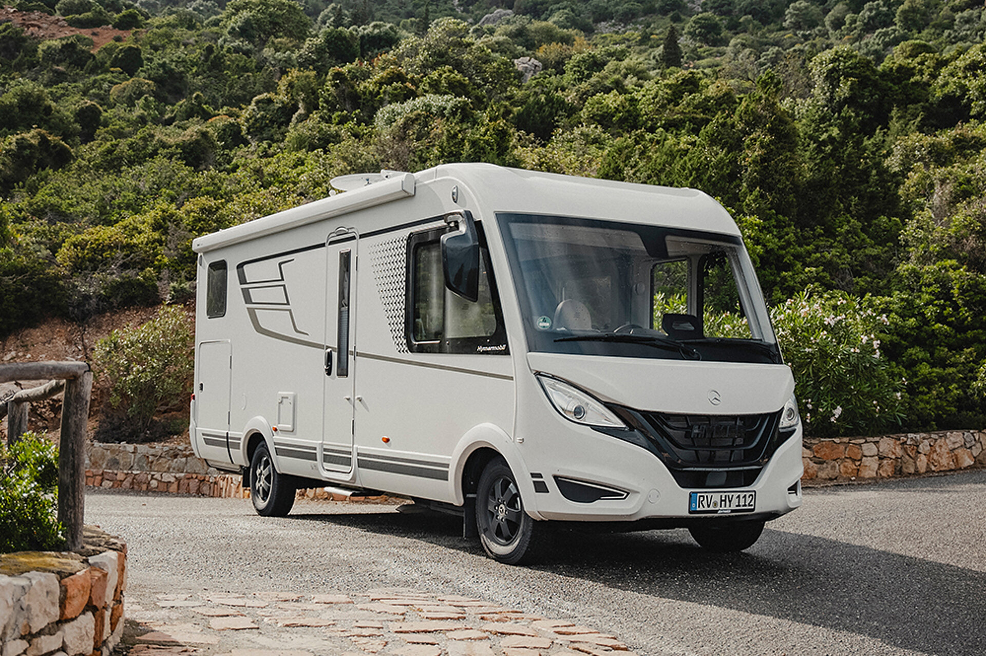 Ein HYMER B-MC I fährt eine gepflasterte Straße auf Sardinien entlang.
