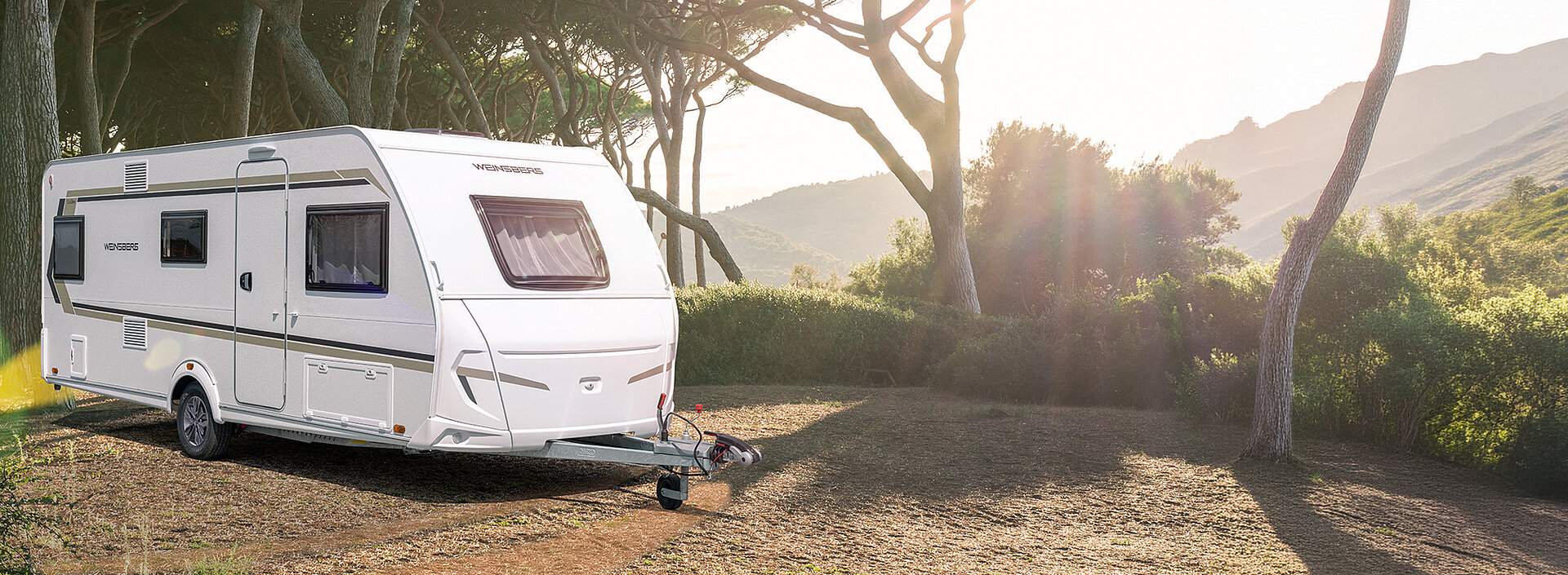 Een witte caravan van WEINSBERG in een mediterrane omgeving.
