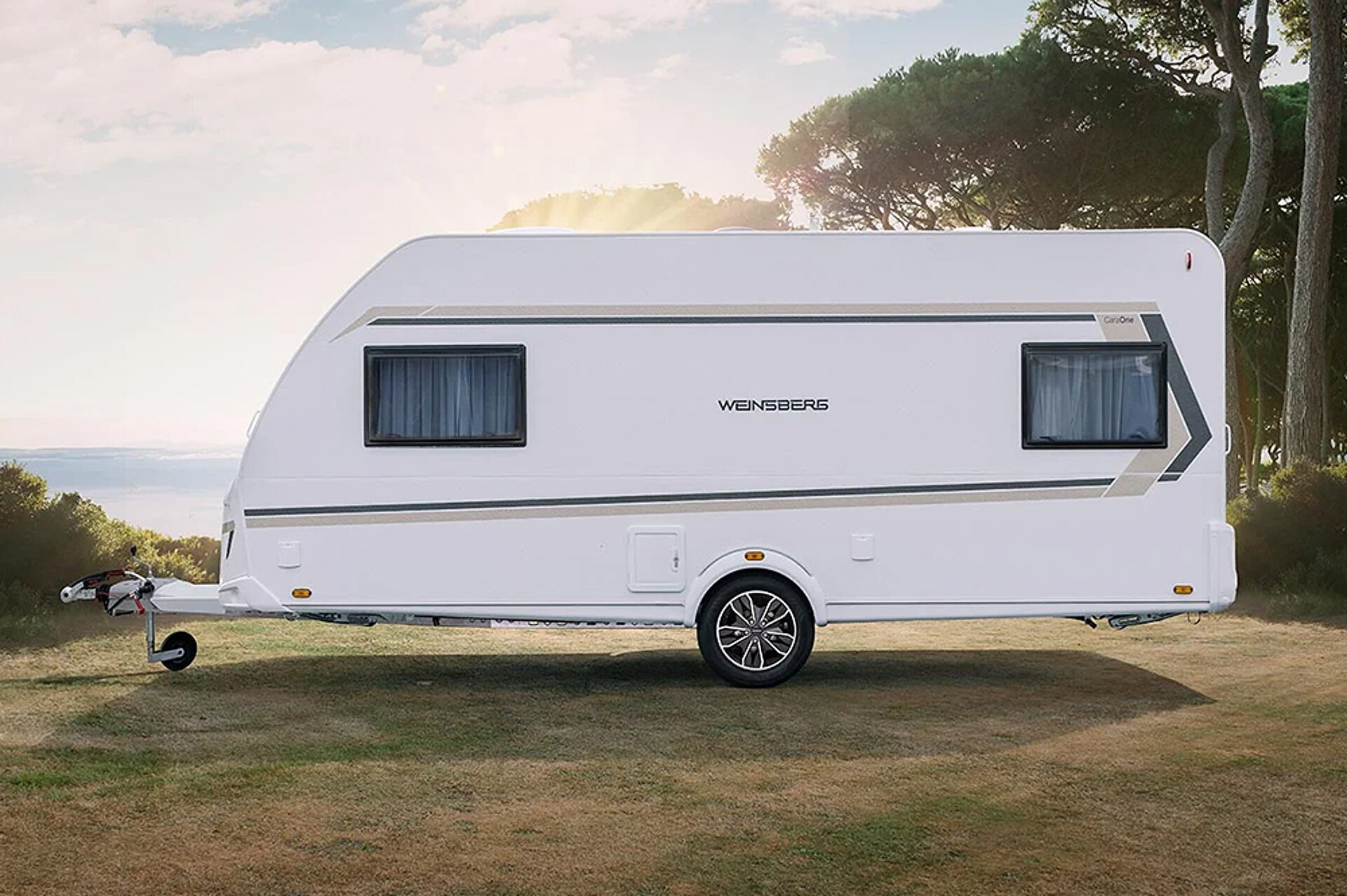 Witte caravan op een weide.