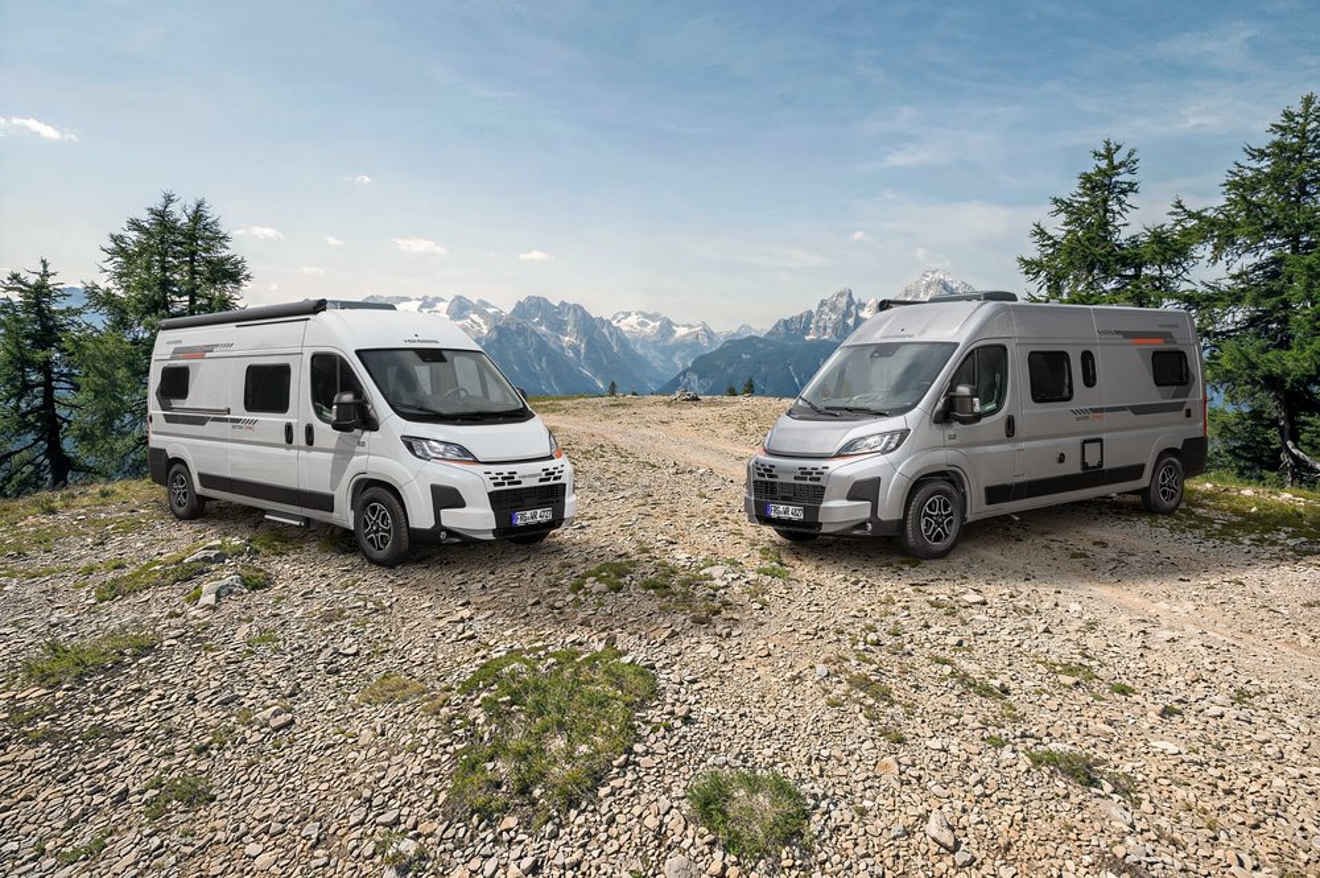 Zwei Camper Vans von WEINSBERG in einer Berglandschaft.
