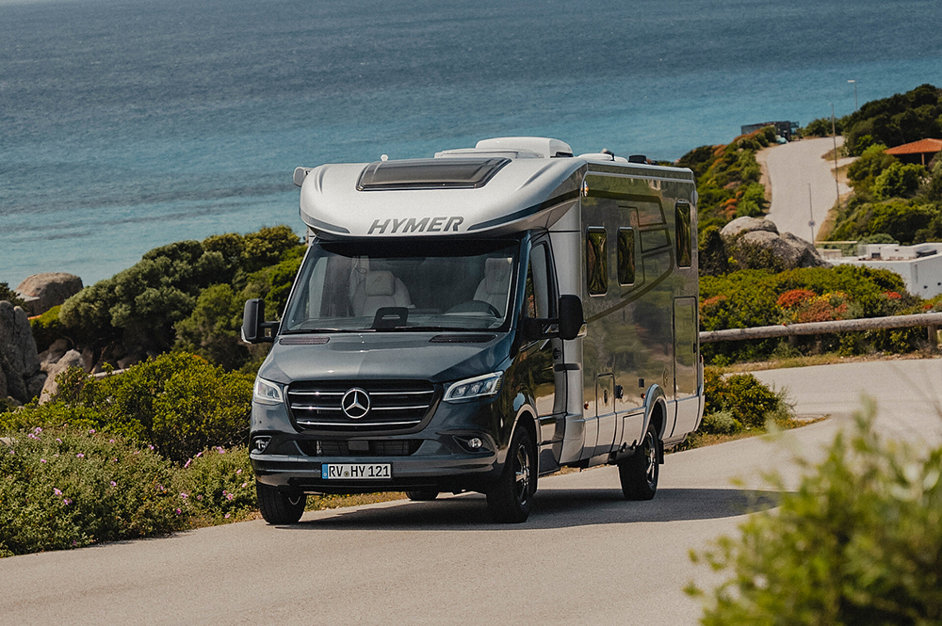 Eine HYMER B-Klasse ModernComfort T fährt eine Küstenstraße auf Sardinien entlang.