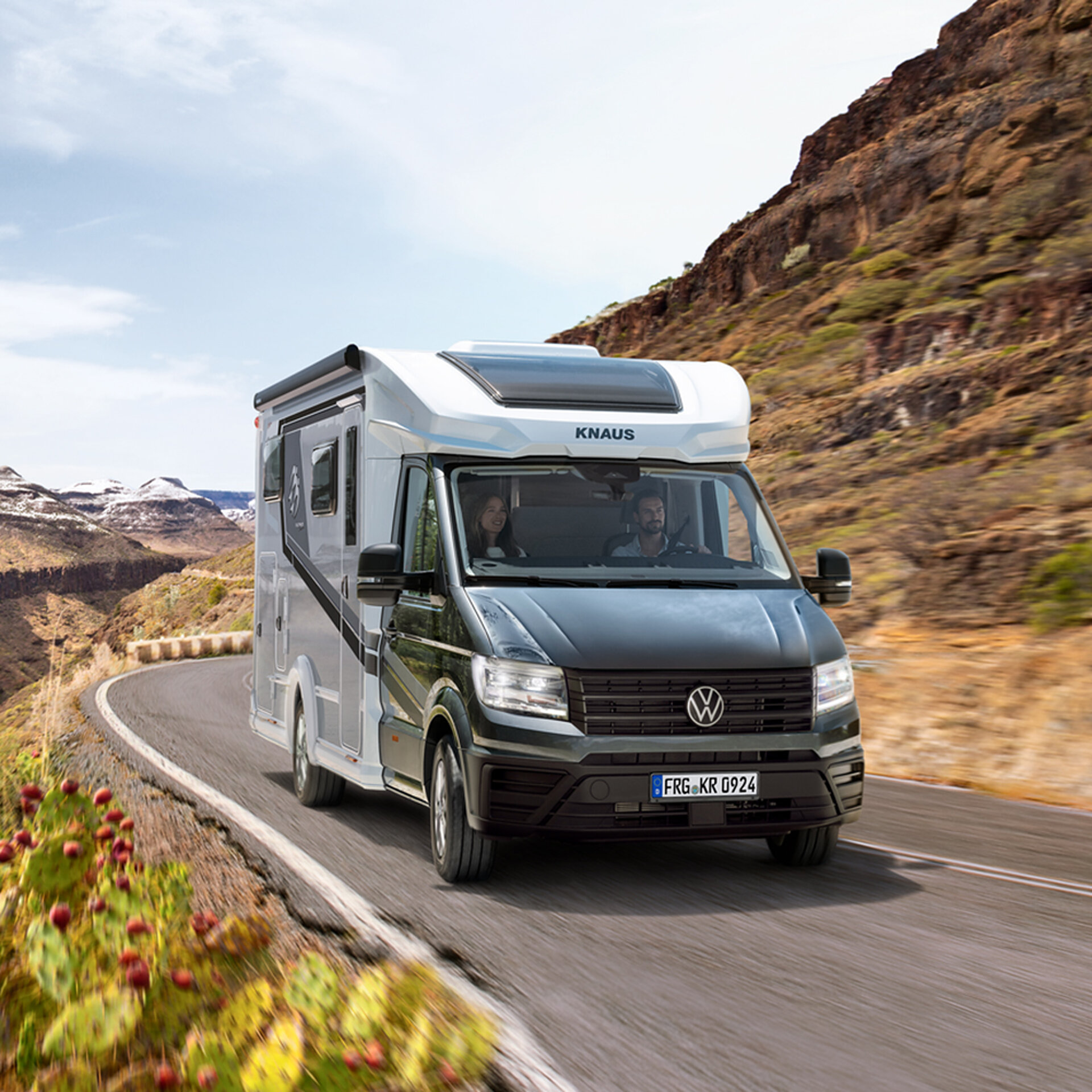 Wohnmobil in einer kargen Landschaft auf einer Straße.