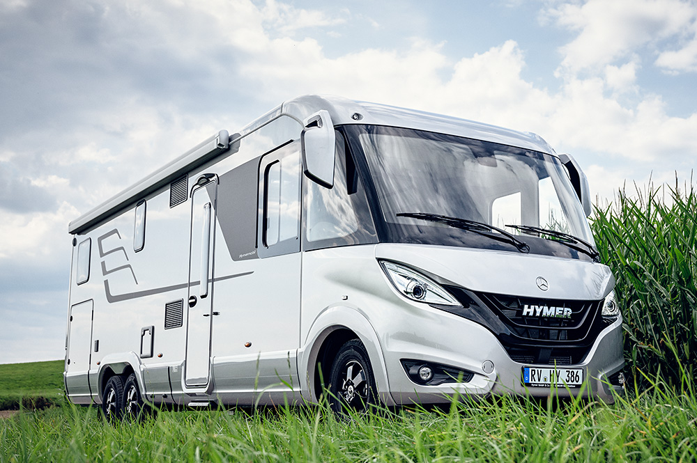 Ein weißes Wohnmobil steht vor einem Maisfeld.