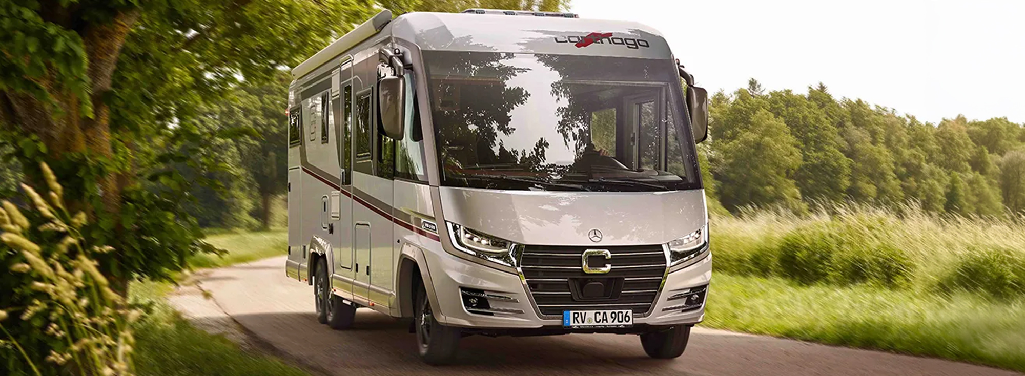 Weißes Reisemobil auf einer Straße.