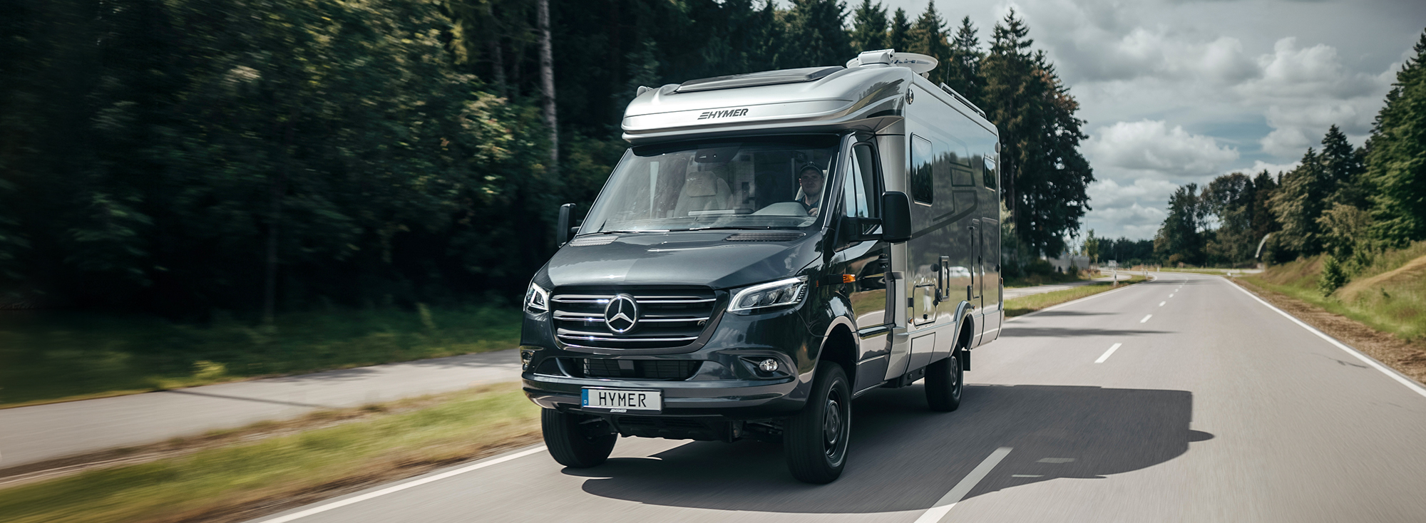 Ein HYMER ML-T Wohnmobil fährt eine Straße entlang.